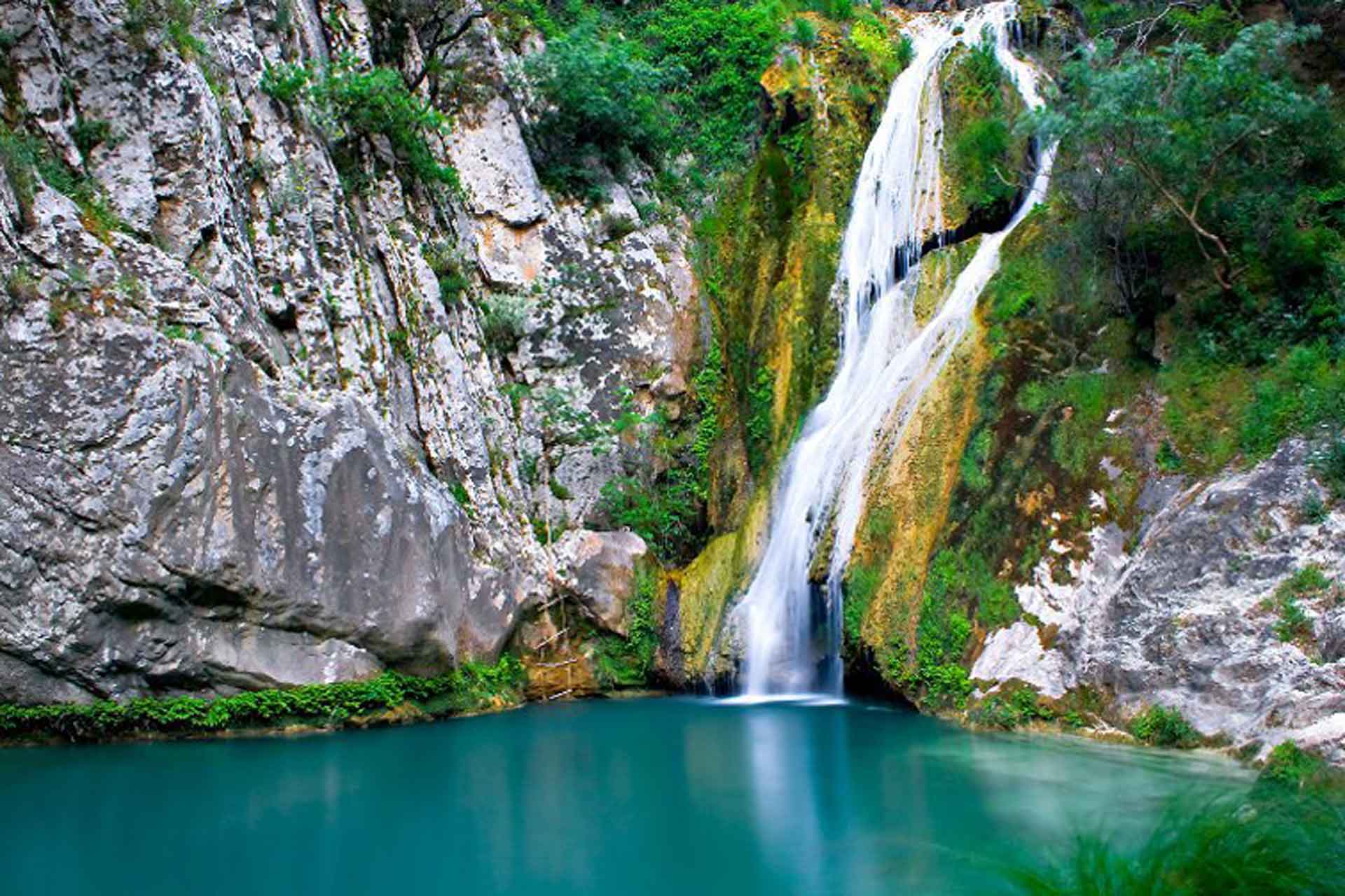 Κοντινό πλάνο του καταρράκτη Νέδα από ψηλά – Τονίζει την καθαρότητα των νερών και την έκταση της πτώσης.